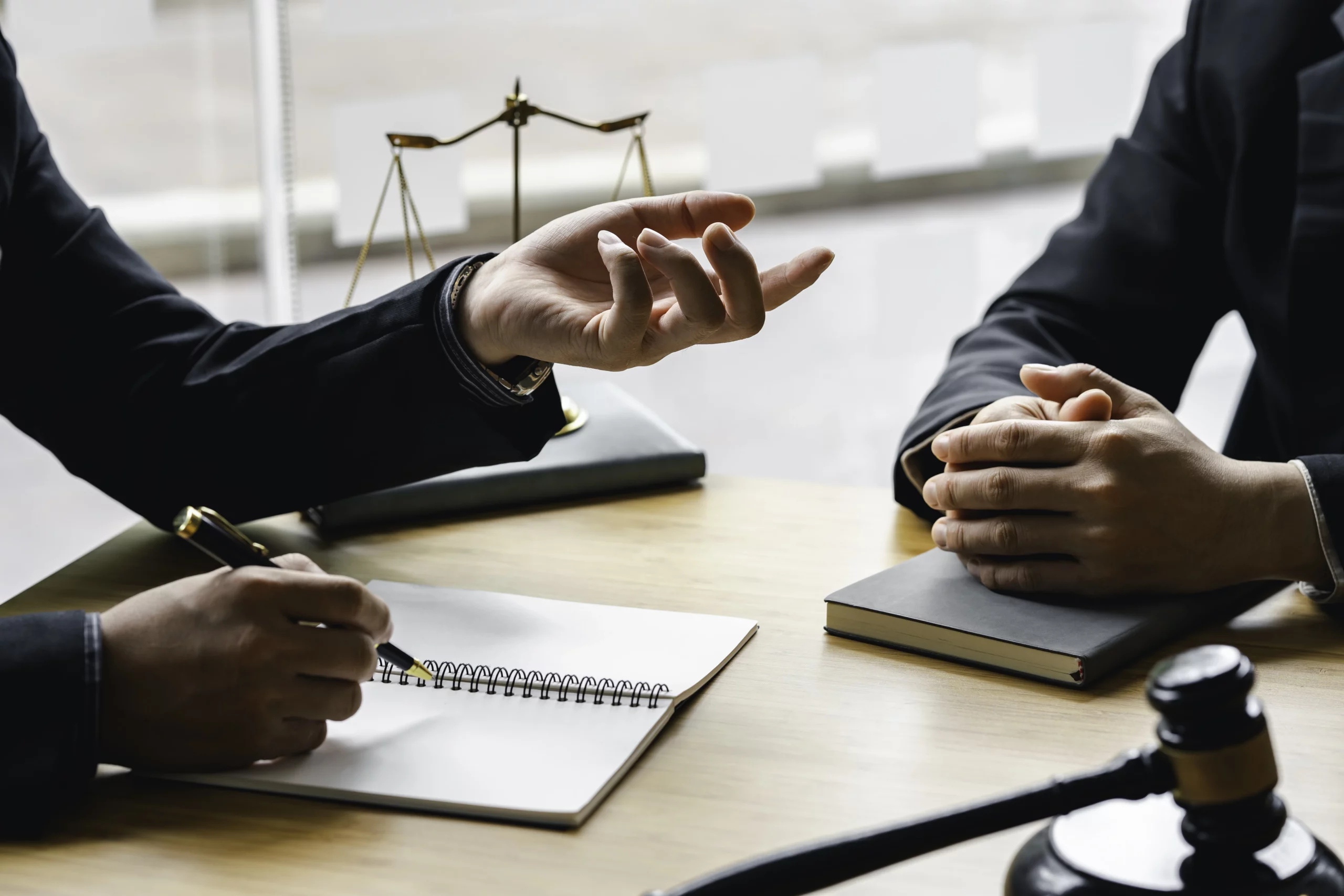 Two professionals in suits discussing bankruptcy matters at a table, with a gavel and scales of justice symbolizing legal guidance.