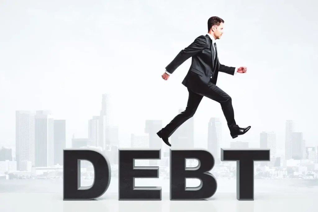 Businessman stepping over the word DEBT, symbolizing overcoming financial challenges through debt relief alternatives in Kentucky.