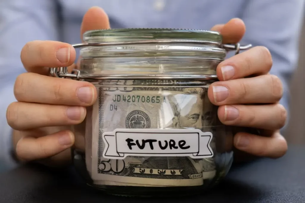 Close-up of hands holding a glass jar filled with dollar bills labeled ‘Future,’ symbolizing financial protection and planning after bankruptcy in Kentucky.