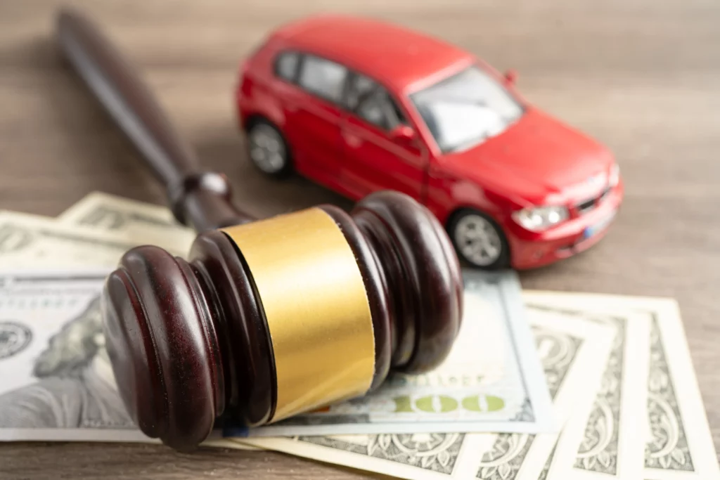 Judge’s gavel on dollar bills beside a toy car, representing whether you can keep your car in Chapter 7 bankruptcy.