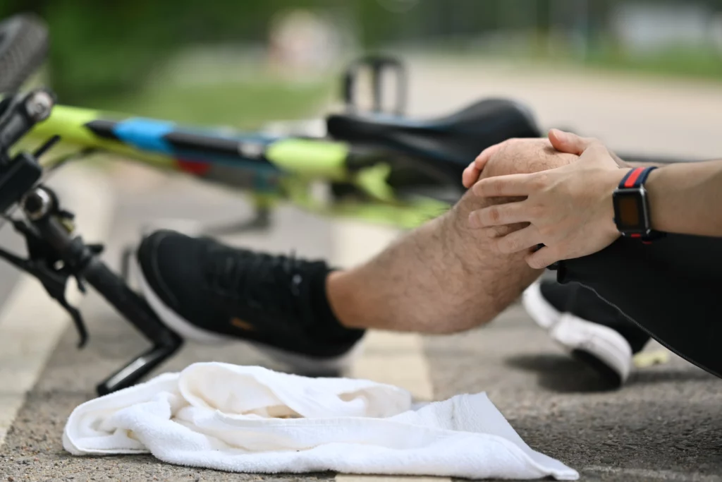 Injured cyclist holding a painful knee after a bicycle accident in Kentucky